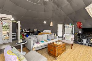 a living room with a couch and chairs in a tent at The Dome in Cloptins Crossing