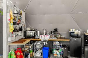 a small kitchen with a counter and a refrigerator at The Dome in Cloptins Crossing +15 photos