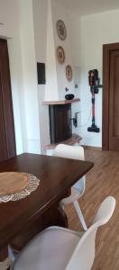 a dining room with a wooden table and white chairs at Villa MB in Lenna