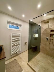 a bathroom with a shower with a toilet and a window at Moderne Wohnung nahe Hockenheimring für bis zu 8 Personen in Hockenheim