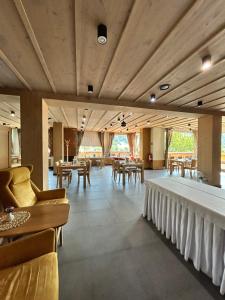 a restaurant with wooden ceilings and tables and chairs at Resort Levočská Dolina in Levoča