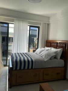 1 dormitorio con 1 cama con marco de madera y ventanas en Mimahs Cozy Getaway near JKIA&SGR at NewRise Gardens, en Nairobi 27 fotos más