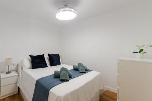 ein weißes Schlafzimmer mit einem Bett mit Handtüchern darauf in der Unterkunft Sun Beach Delfín Verde Apartamento E11 in Benalmádena + 21 Fotos