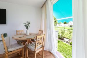 ein Esszimmer mit Tisch und Stühlen und einem Fenster in der Unterkunft Sun Beach Delfín Verde Apartamento E11 in Benalmádena