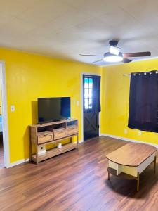 a living room with yellow walls and a flat screen tv at Pet friendly newly renovated home in Central Okc in Oklahoma City
