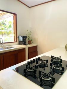a black stove top in a kitchen with a sink at Casa Positano Pipa in Pipa