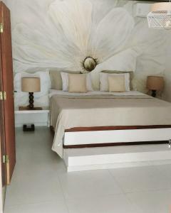 a bedroom with a large white bed with two lamps at Casa Positano Pipa in Pipa