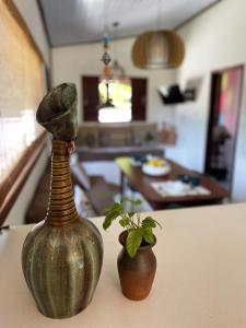 a green vase and a plant on a table at Casa Positano Pipa in Pipa +17 photos