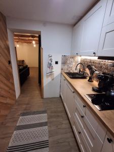 una cucina con mobili bianchi e un piano di lavoro di Sądelska Chałpa a Murzasichle