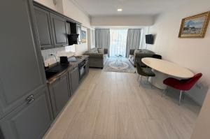 a kitchen and a living room with a table at Maritimo ApartHotel in Constanţa