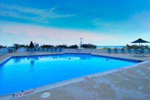 a large blue swimming pool with chairs and an umbrella at Pyramid 6G in Ocean City