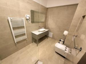 a bathroom with a toilet and a sink and a mirror at Maritimo ApartHotel in Constanţa +33 photos