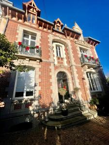 een groot bakstenen gebouw met ramen en potplanten bij Charmante petite maison d'exception classée in Saint-Brieuc