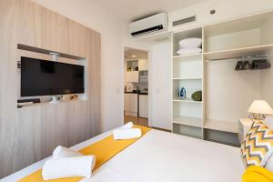 a bedroom with a bed and a tv on a wall at MP/1212-Flat completo no Hotel Mercure Pinheiros in Sao Paulo