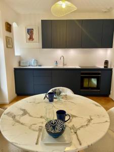 a kitchen with a white table with a bowl and cups at Charmante petite maison d'exception classée in Saint-Brieuc +2 photos