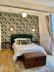 een slaapkamer met een bed met een groen hoofdeinde bij Charmante petite maison d'exception classée in Saint-Brieuc +4 foto's