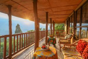 a porch of a house with a table and chairs at Gorilla Retreat Ecolodge -Bwindi Forest in Bwindi