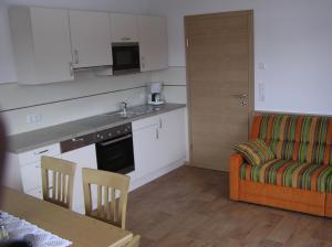 kuchnia i salon z kanapą i stołem w obiekcie Appartements Luegeck w mieście Hollersbach im Pinzgau