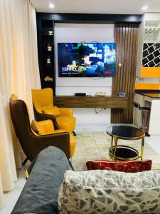 ein Wohnzimmer mit Fernseher, Couch und Sesseln in der Unterkunft Calib Apartments in Ikate + 2 Fotos