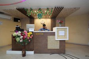a man sitting at a reception desk in a lobby at Hotol O River Bay Resort in Diamond Harbour