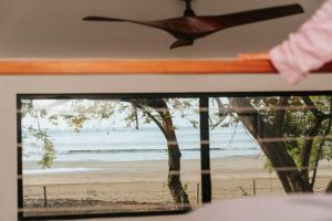 a window with a view of a beach at Soul - Oceanfront Jungle Loft in Playa Venao