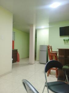 an empty room with chairs and a table and a refrigerator at Apartamento central Yahweh in San Andrés