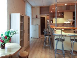 a kitchen with a bar and stools in a room at Seaside Park Apartment in Liepāja