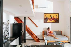 a woman sitting on a couch in a living room at Body - Oceanfront Jungle Loft in Playa Venao +63 photos