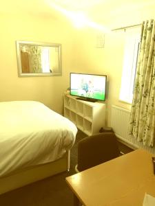 a bedroom with a bed and a tv and a chair at High class accommodations 10 in Little Hulton