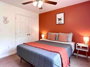 a bedroom with a bed with an orange wall at Pocolonial Charming 4BR Mountain Retreat in Towamensing Trails