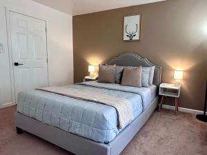 a bedroom with a large bed with two lamps at Pocolonial Charming 4BR Mountain Retreat in Towamensing Trails +51 photos