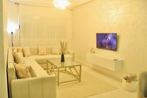 a living room with a white couch and a table at Yasmine Elixir in Casablanca