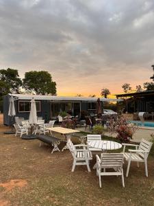 un grupo de sillas y mesas delante de un remolque en Jardim dos Sentidos no Lago Sul, en Brasilia