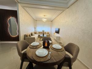 a living room with a wooden table and chairs at Yasmine Elixir in Casablanca