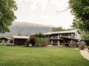 ein Haus mit Rasen und Bergen im Hintergrund in der Unterkunft Similkameen Valley Resort in Cawston