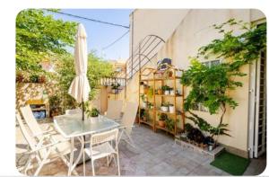 patio con tavolo, sedie e ombrellone di Retales a Cartagena