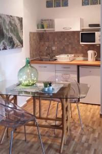 una cucina con tavolo in vetro e 2 sedie di Retales a Cartagena
