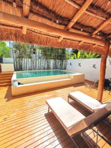 a deck with two chairs and a swimming pool at Casa alado de la playa in Cancún
