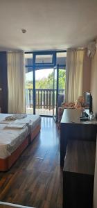 a hotel room with two beds and a desk and a desk at Семеен хотел Звезда in Sŭdievo