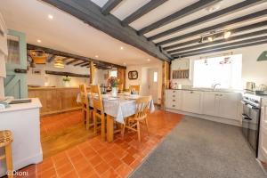 a kitchen and dining room with a table and chairs at Allt-Goch in Llanbedr