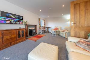 a living room with a couch and a tv at Allt-Goch in Llanbedr