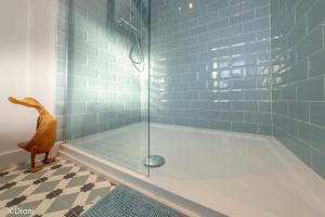 a bathroom with a shower with blue tiles at Allt-Goch in Llanbedr +26 photos