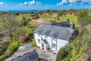 an aerial view of a white cottage in a field at Allt-Goch in Llanbedr