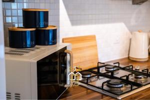 a stove top oven with two pots on top of it at Hammerman Residence - SJA Stays - 3 Bed Apartment With Parking in Aberdeen