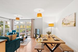 a living room with a table and a blue couch at Hammerman Residence - SJA Stays - 3 Bed Apartment With Parking in Aberdeen