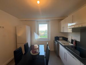 Una pequeña cocina con una mesa y una ventana. en Jsj, en Rodez