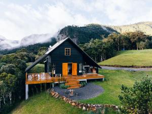 ein Haus auf einem Hügel mit Bergen im Hintergrund in der Unterkunft Chalé Exclusivo com Spa e Vista Mágica, Top Urubici in Urubici