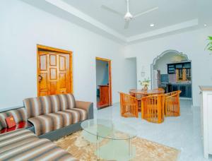 a living room with a couch and a glass table at Joy Villa Garden in Batticaloa