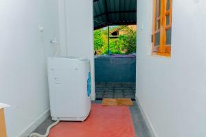 a bathroom with a trash can in a hallway at Joy Villa Garden in Batticaloa