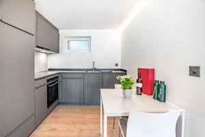 eine Küche mit einem weißen Tisch und weißen Stühlen in der Unterkunft Completely renovated, furnished studio with plenty of comfort in Visp + 8 Fotos